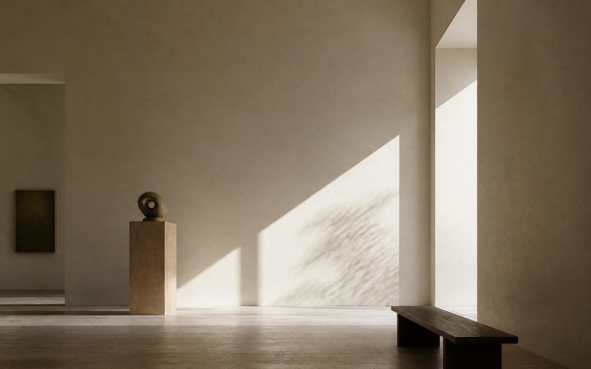 Sunlight crossing a travertine gallery hall with a sculptural stone form on a plinth